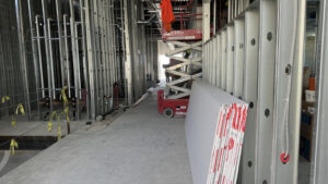 Interior image of framed room with drywall stacked against framing