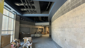 A hallway with a concrete wall and glass window