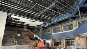 A wide shot of the auditorium with an orange crane parked inside of the auditorium.