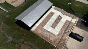 Overhead drone image of Pavilion with chainlink fencing and concrete ramp leading through sod and gravel to pavilion