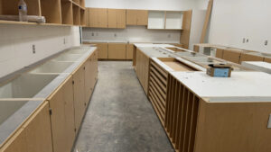 A Shoreline Middle Faculty Storage Room and workspace, stacked with brown cabinetry and laminated countertops.