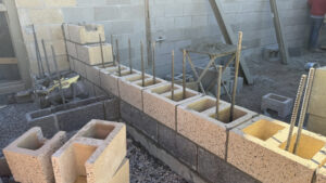 A paved wall with masonry stacked within rebar.