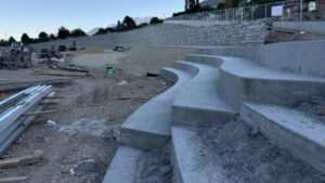 This is the sloping landscape and cement seating pads that surround the playground construction lot.