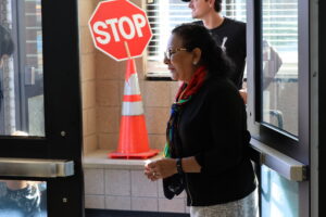 A school administrator welcomes in new students to the school.