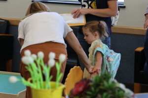 An administrator holds the hand of a new student.