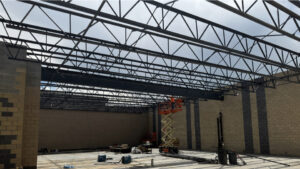 A low-angled shot of the northern gym interior roofing beams.