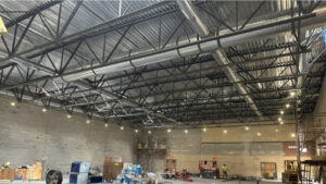 A low-angled shot of the northern gym interior roofing beams.