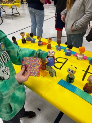 A student looks at his handcrafted bobble head.