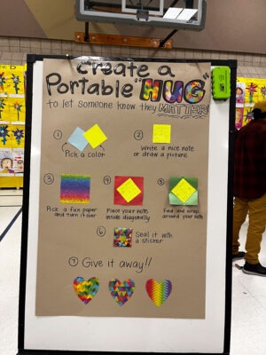 A display for a make-and-take project. It gives step by step directions on "creating a portable hug."