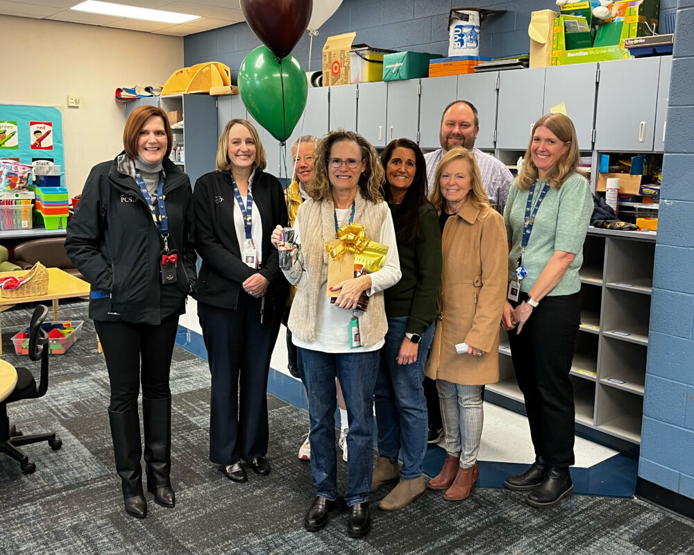 Teacher Denise Johnson stands in the center of the Foundation group, including Superintendent Dau and Principal Porter. 