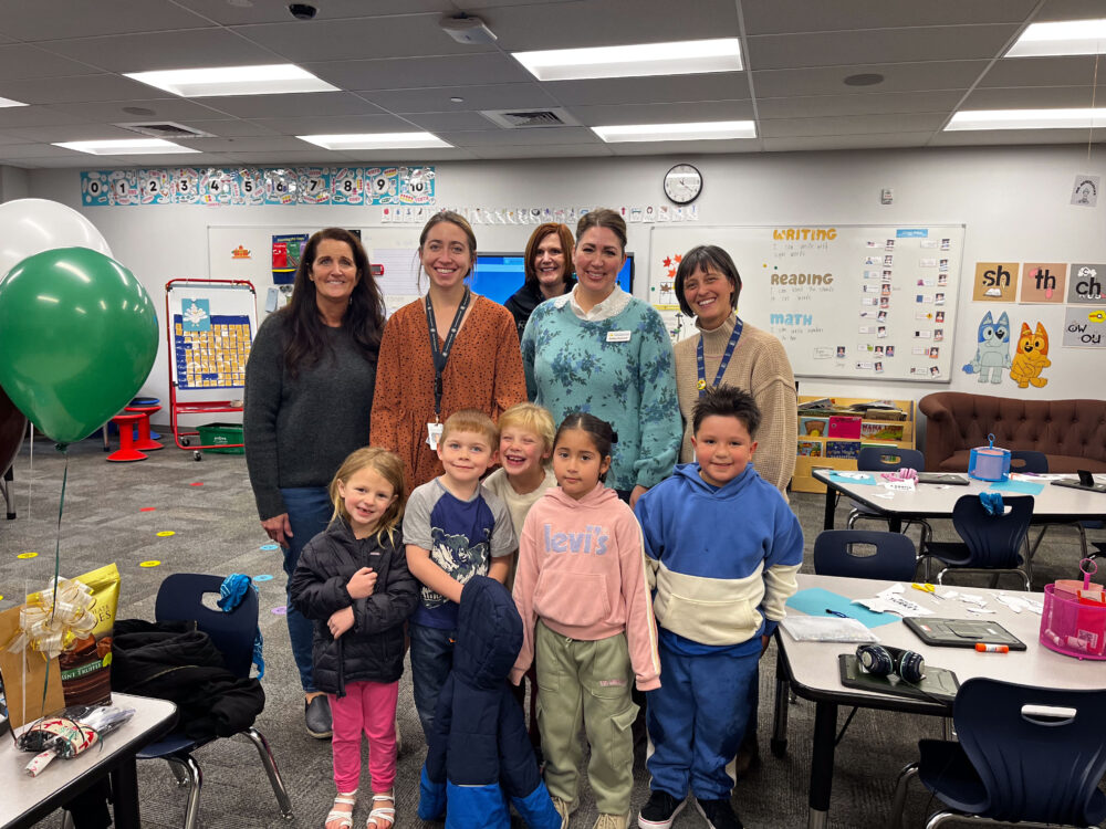 Teacher Josephine Kelemen stands in the center of a group of students and the Foundation, including Superintendent Dau. 