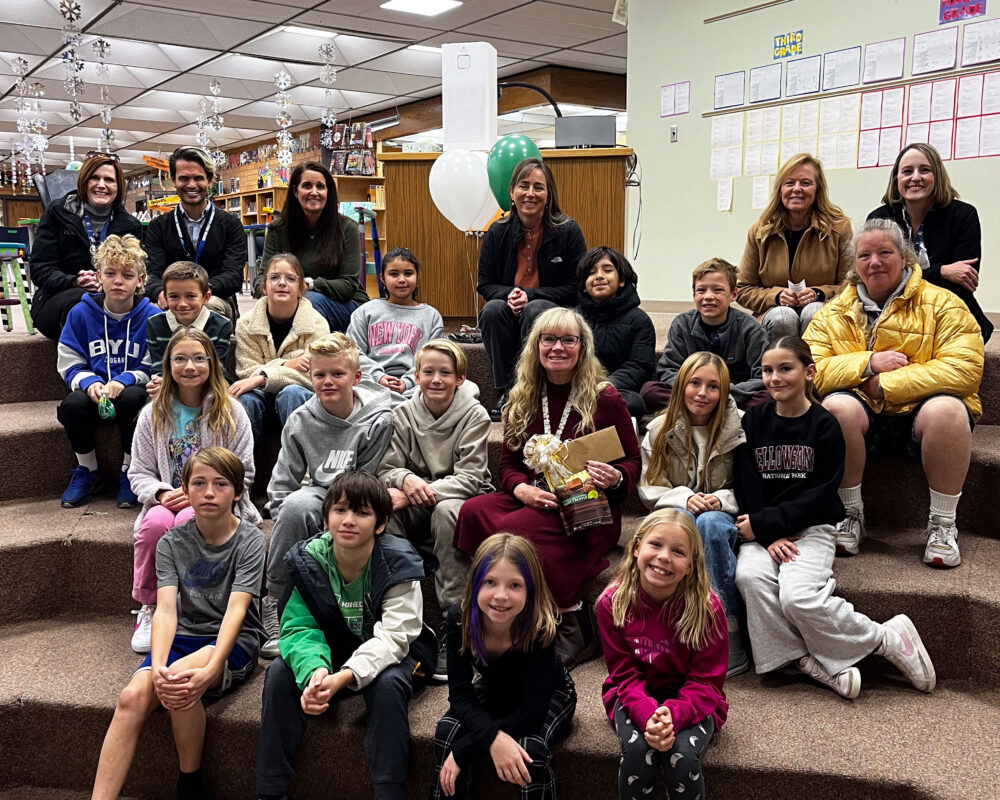 Launa Naylor stands in the center of a group of students and the Foundation, including Superintendent Dau and Principal Edwards. 