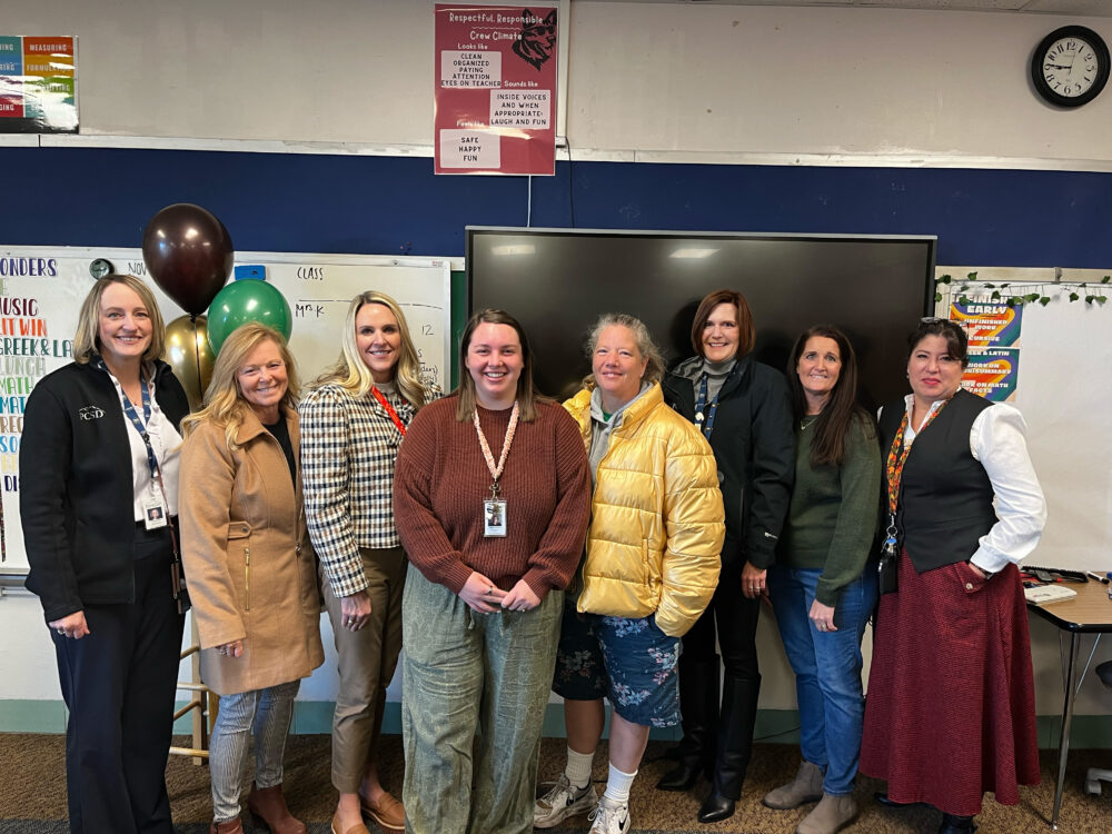 Teacher Lauryn Kirokiro stands in the center of the Foundation group, including Superintendent Dau and Principal Snow. 