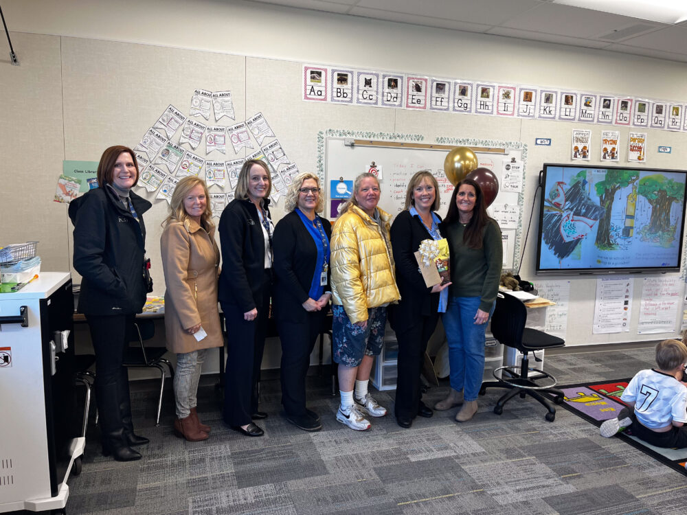 Teacher Lisa Garner stands in the center of the Foundation group, including Superintendent Dau and Principal Kartchner. 