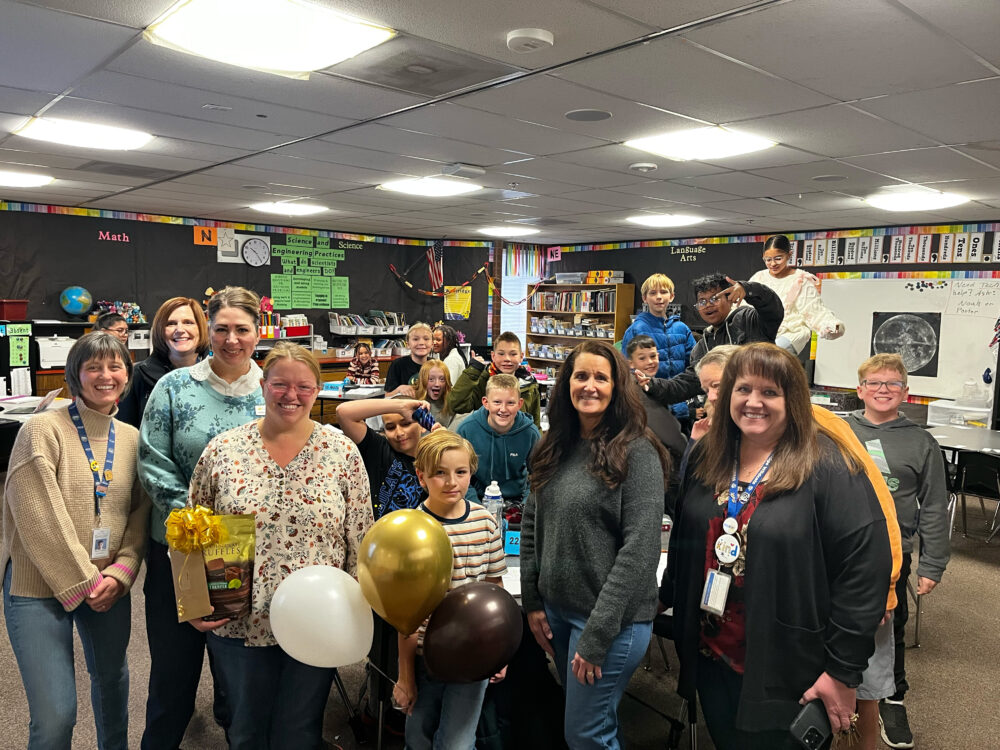 Teacher Mashell Stott stands in the center of a group of students and the Foundation, including Superintendent Dau and Principal Hawkins. 