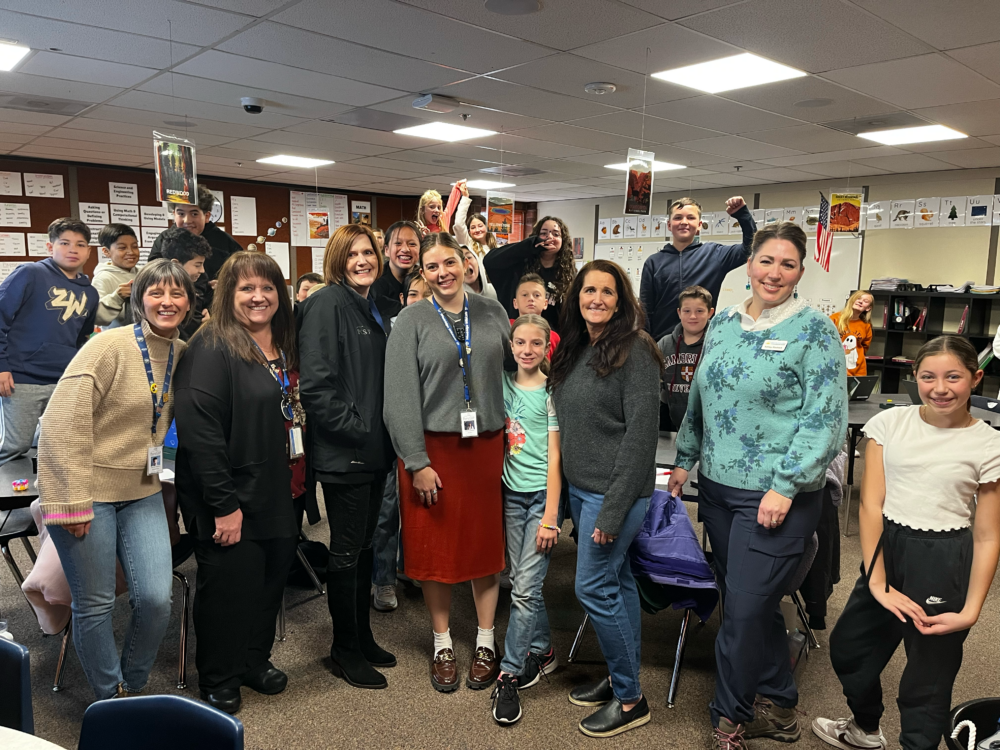 Teacher Abbey Chambers stands in the center of a group of students and the Foundation, including Superintendent Dau. 