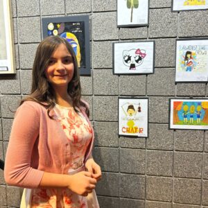 Student standing next to their art work.