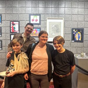 Family stood next to student and their art at Covey Center.