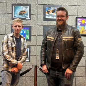 Student and teacher stood next to their artwork at Covey Center.