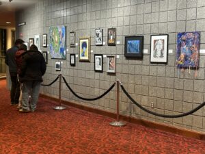 Several paintings line a wall.