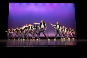 Dancers pose on a stage.