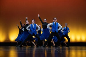 Dancers pose on a stage.