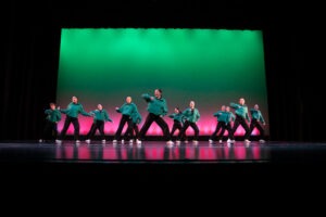 Dancers pose on a stage.