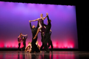 Dancers pose on a stage.