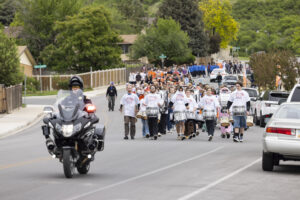 Students follow a police escort down an empty road.
