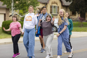 A group of students are waving at the camera.